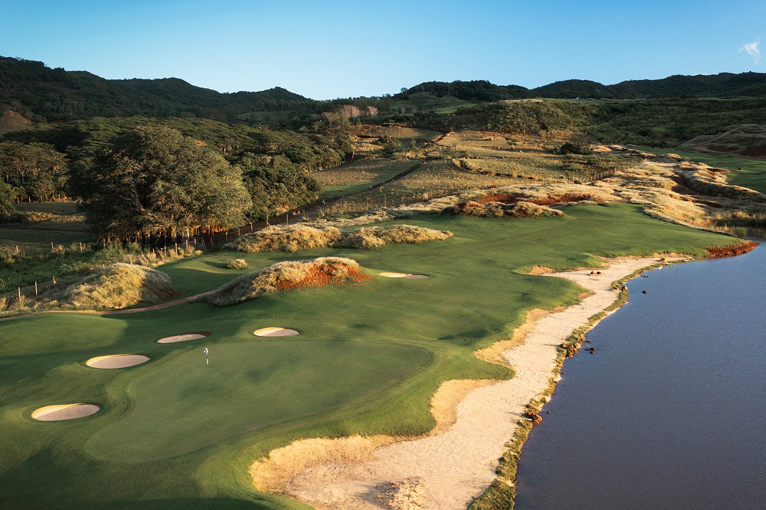 Aerial view of La Réserve Golf Links, its bunkers running along the water